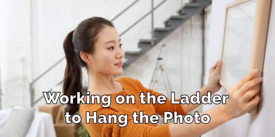 working-on-the-ladder-to-hang-the-photo