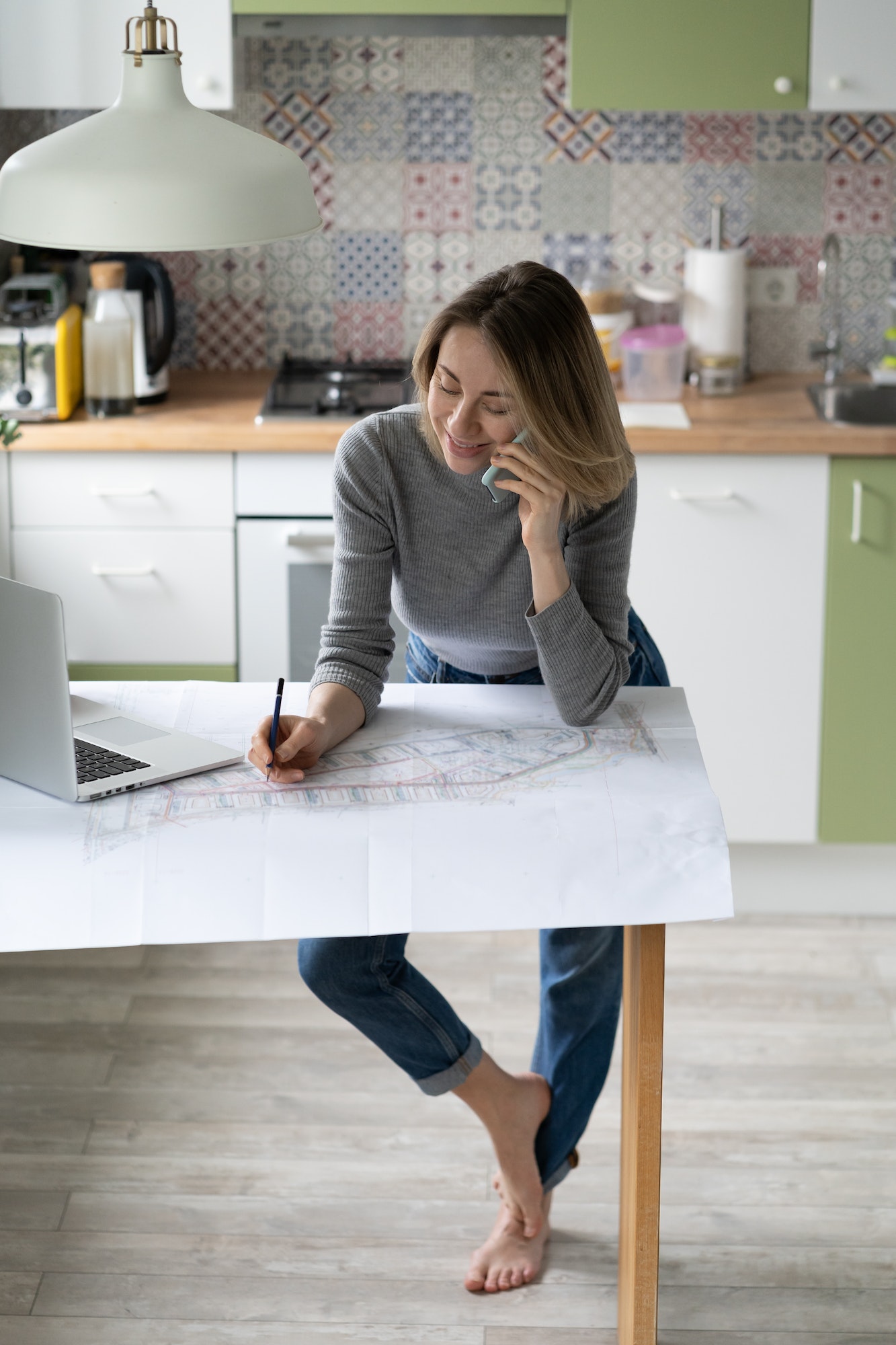 woman-talking-on-cellphone-discusses-the-details-of-an-architectural-project-makes-notes-on-drawing.jpg